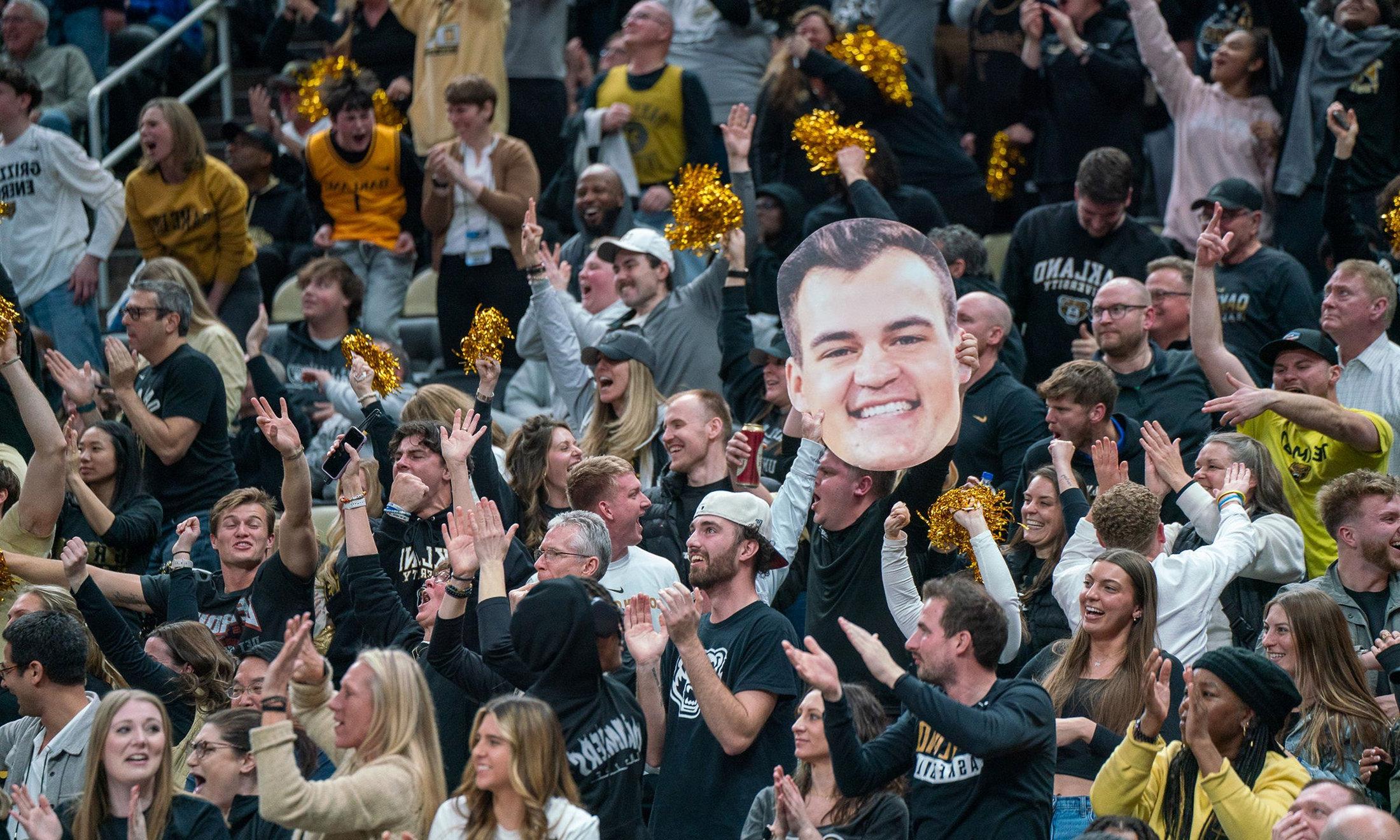 A crowd holding a cardboard cutout of Jack Gohlke's face